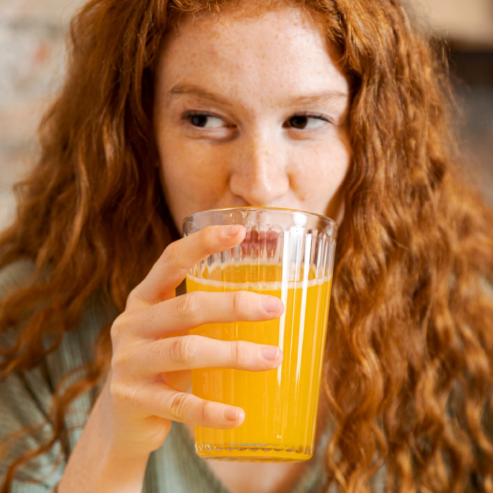 Persona bebiendo jugo de naranja Dairyco